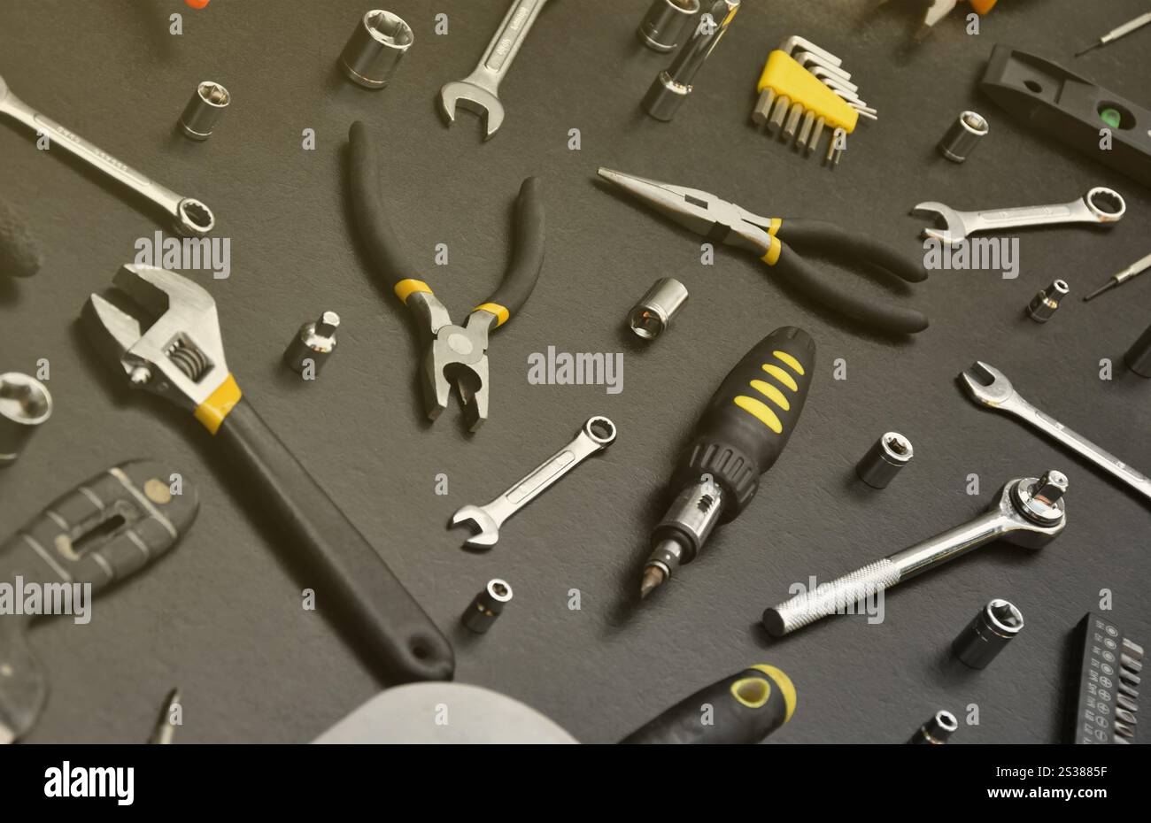 Kit d'outils bricoleur sur table en bois noir. De nombreuses clés et tournevis, pilers et autres outils pour tout type de travaux de réparation ou de construction. Banque D'Images