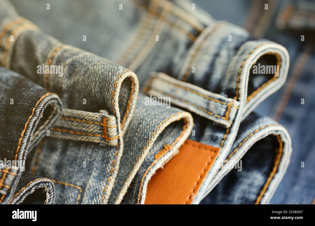 Beaucoup de jeans en pile dans la salle de garde-robe. Rangée de pantalons Jean denim dans le placard. Concept d'achat, vente, shopping et vêtements modernes à la mode. Beaucoup de jeans Banque D'Images