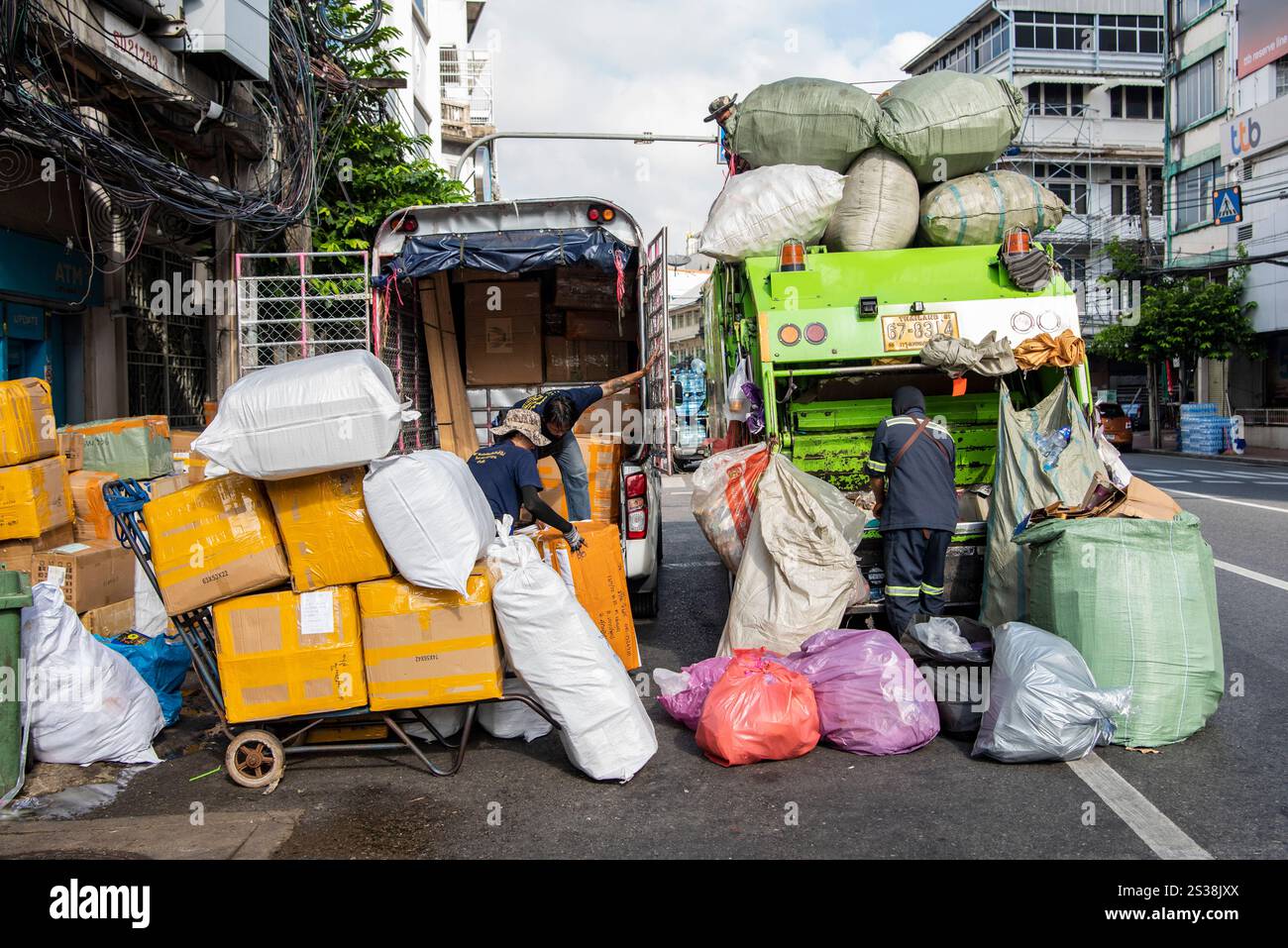 Un transport de marchandises, à gauche, un camion de déchets et de recyclage, à droite, sur la route de Yaowarat dans China Town dans la ville de Bangkok en Thaïlande. Thaïlande, Banque D'Images