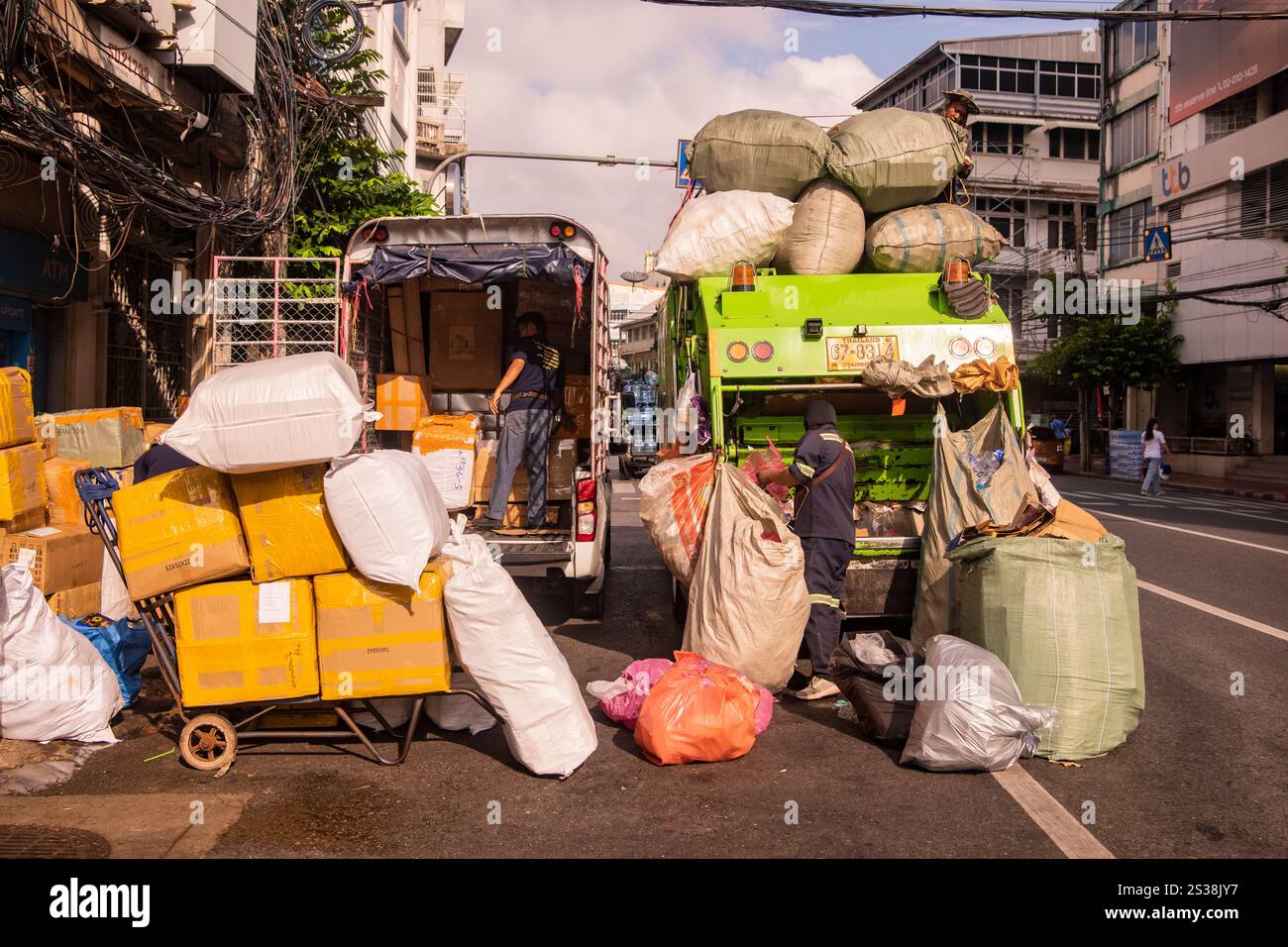 Un transport de marchandises, à gauche, un camion de déchets et de recyclage, à droite, sur la route de Yaowarat dans China Town dans la ville de Bangkok en Thaïlande. Thaïlande, Banque D'Images