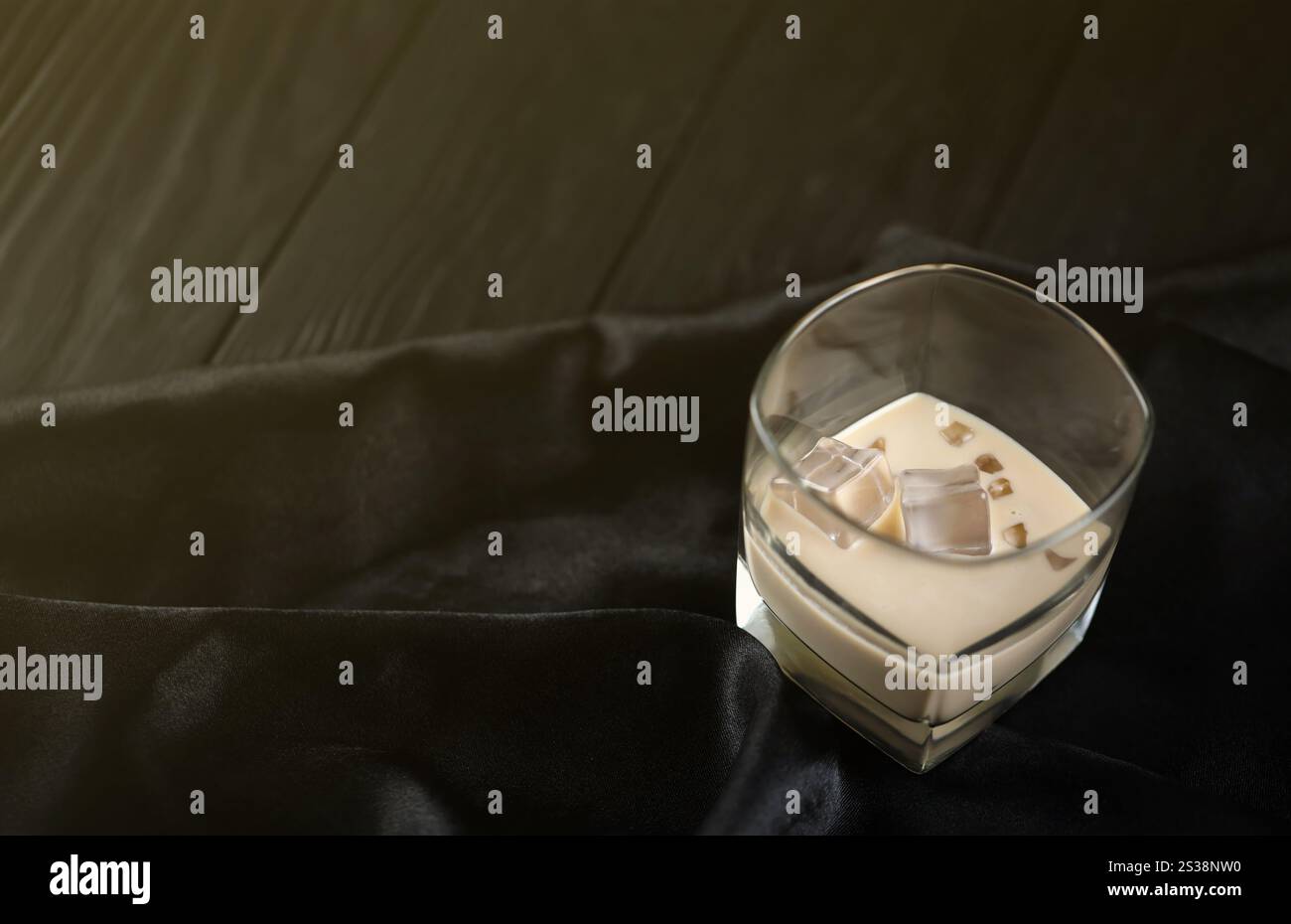 Verre de liqueur baileys de crème irlandaise avec glaçons sur toile sombre et arrière-plan de table en bois. Cocktail d'alcool haut de gamme fait maison. Placer pour Banque D'Images