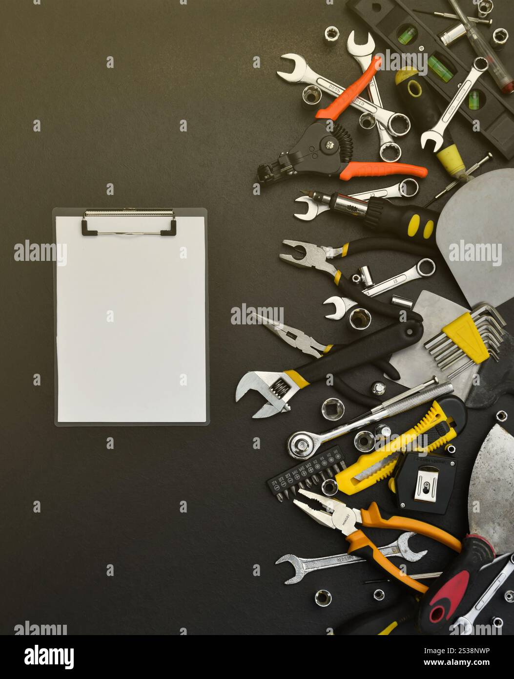 Kit d'outils bricoleur sur table en bois noir. De nombreuses clés et tournevis, pilers et autres outils pour tout type de travaux de réparation ou de construction. Banque D'Images