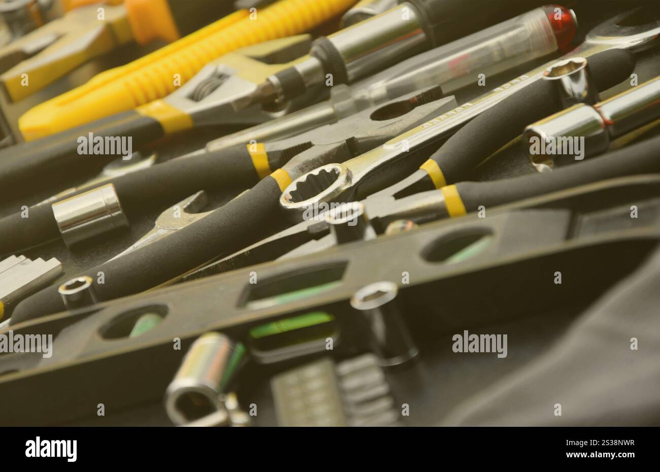 Kit d'outils bricoleur sur table en bois noir. De nombreuses clés et tournevis, pilers et autres outils pour tout type de travaux de réparation ou de construction. Banque D'Images