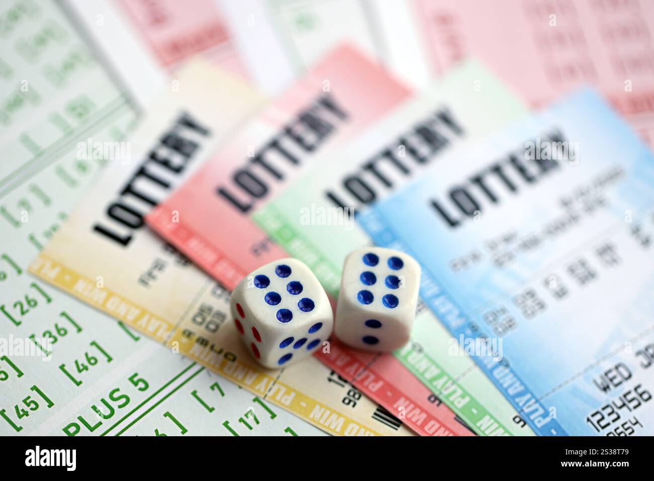 Billets de loterie de différentes couleurs et dés sur des billets vierges avec des numéros pour jouer à la loterie en gros plan. Billets de loterie de différentes couleurs et dés Banque D'Images