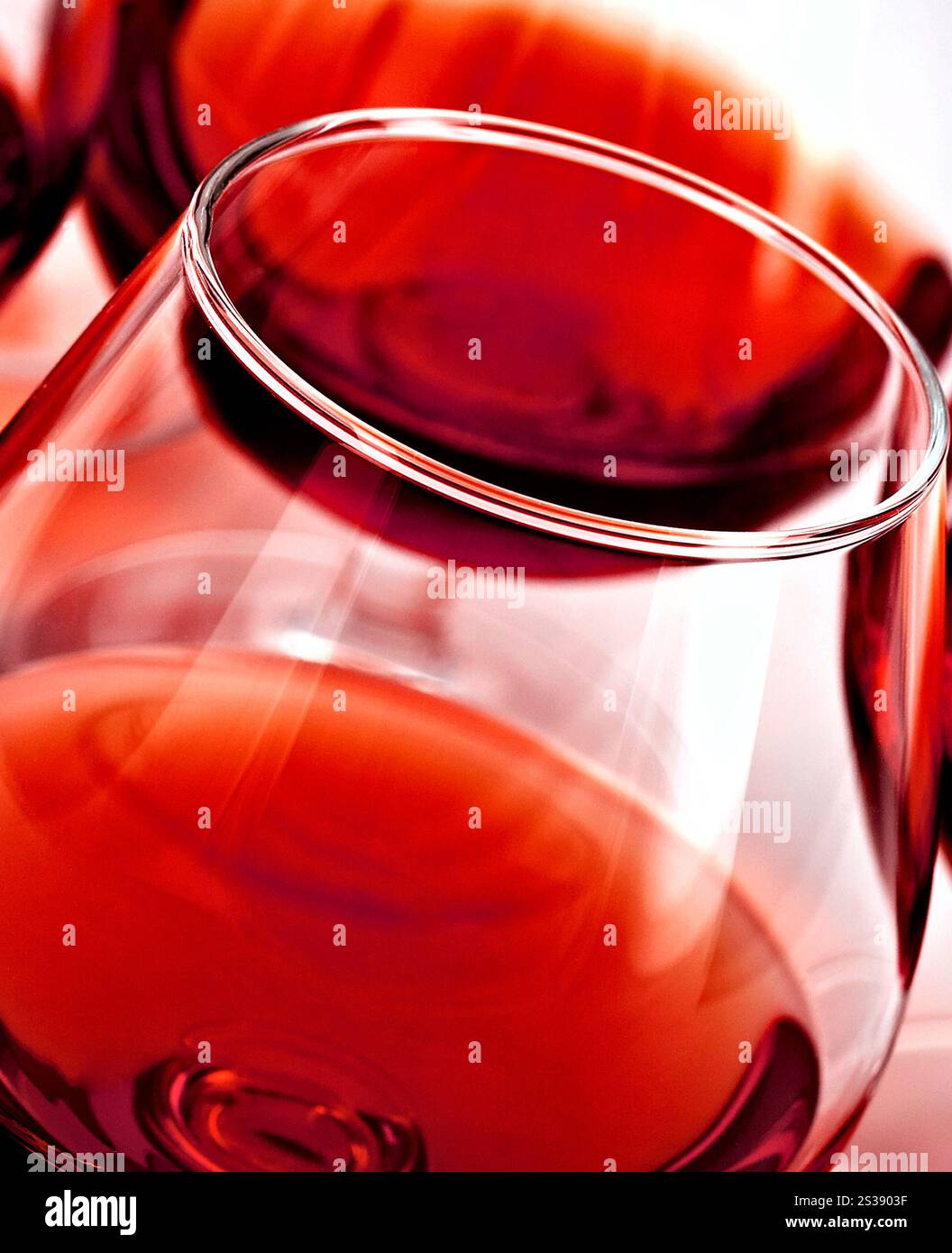 Gros plan artistique d'un verre à vin à pointe avec du vin rouge, avec un accent sur la forme et la couleur. Gros plan abstrait d'un verre de vin rouge Banque D'Images