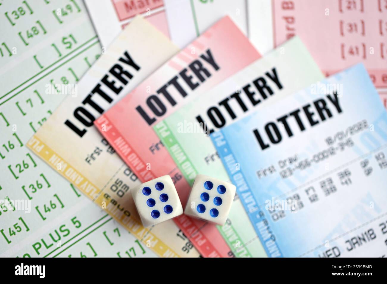 Billets de loterie de différentes couleurs et dés sur des billets vierges avec des numéros pour jouer à la loterie en gros plan. Billets de loterie de différentes couleurs et dés Banque D'Images