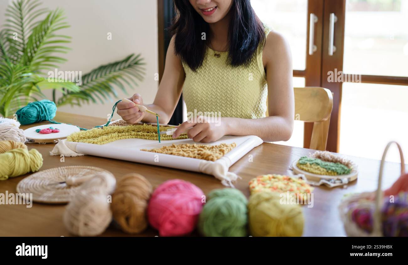 Aiguille perforée. Femme asiatique faisant tricoter Hobby à la main dans l'atelier de studio. Designer Workplace projet artisanal fait à la main concept de broderie DIY Banque D'Images