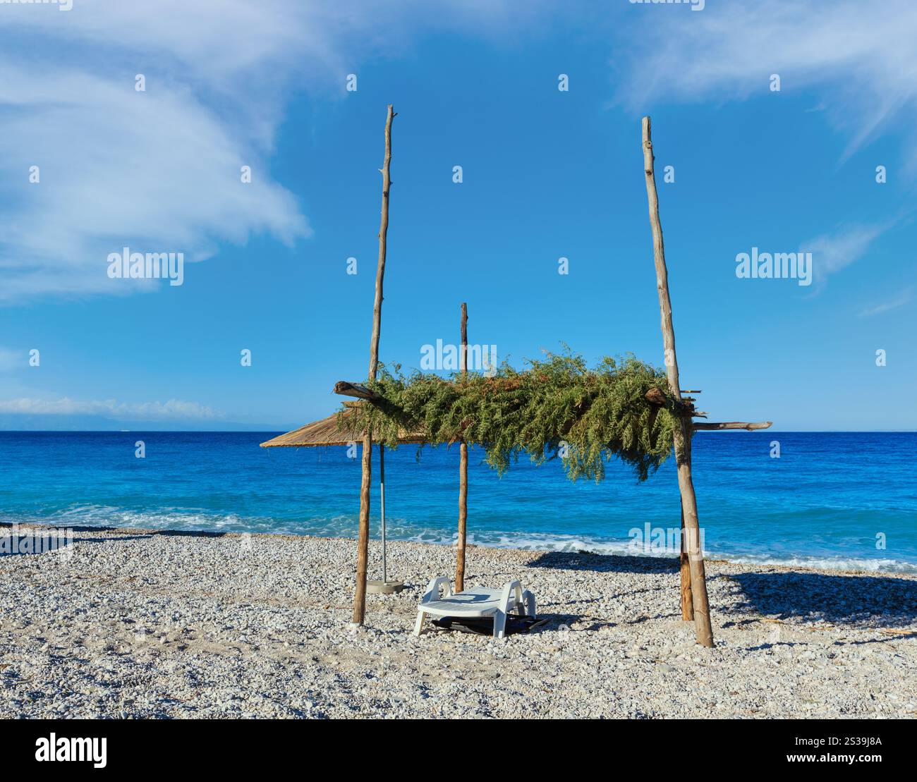 Matin d'été plage de galets avec transats et couvert (Albanie). Banque D'Images