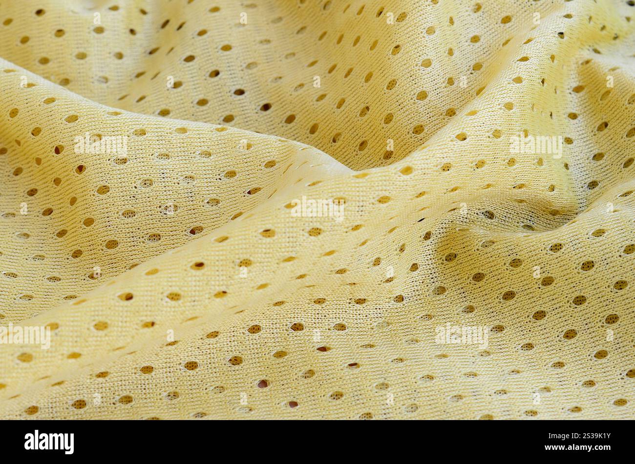 Fond de modèle textile de tissu de tissu de sport de maille jaune. Couleur jaune maillot de football vêtements tissu texture vêtements de sport. Poreux respirant Banque D'Images