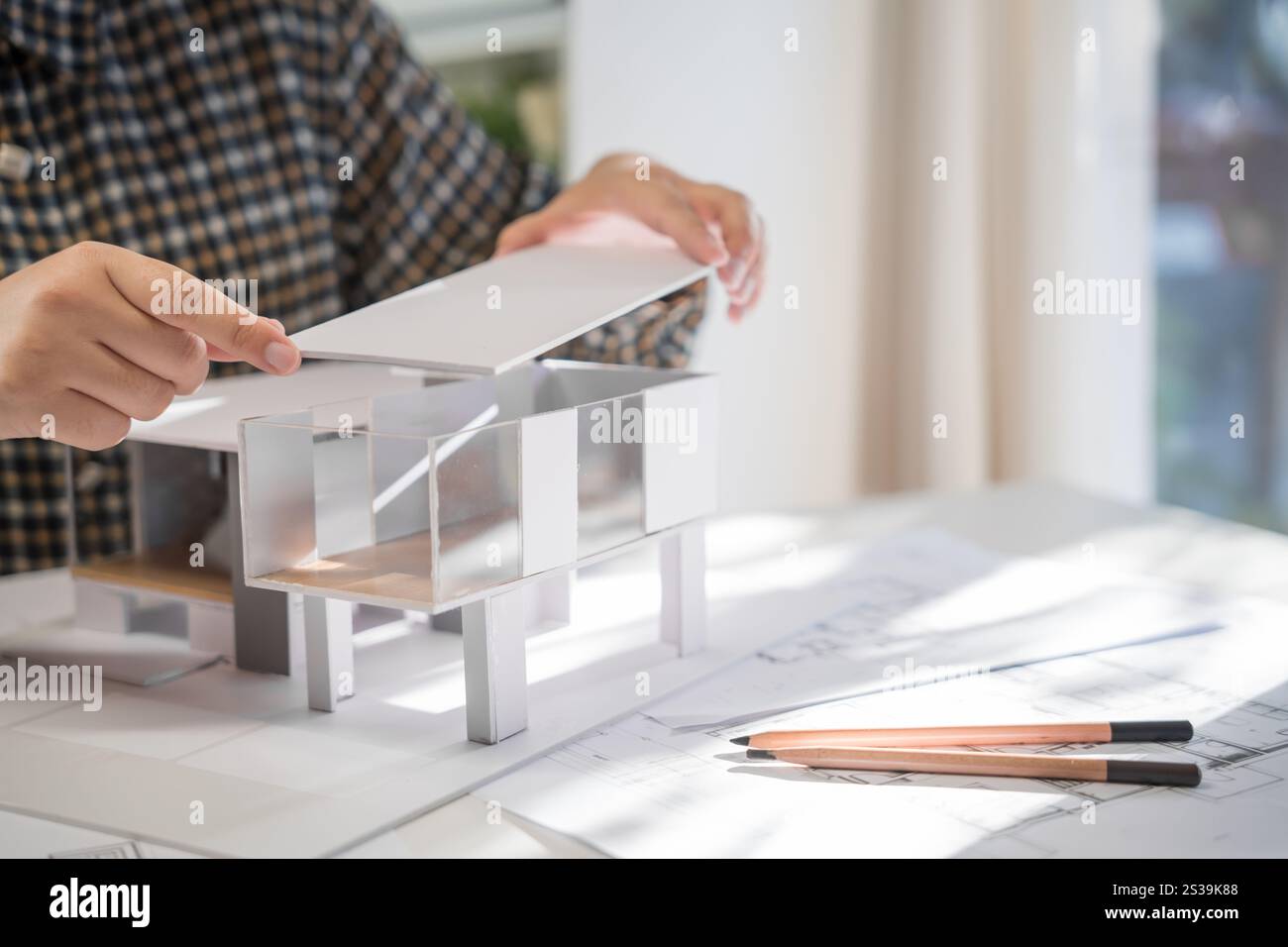 Modèle de maison sur Buleprint construction dessin et équipement de dessin stationnaire architecte analysant maison modèle moderne dans la main architecte Design Banque D'Images