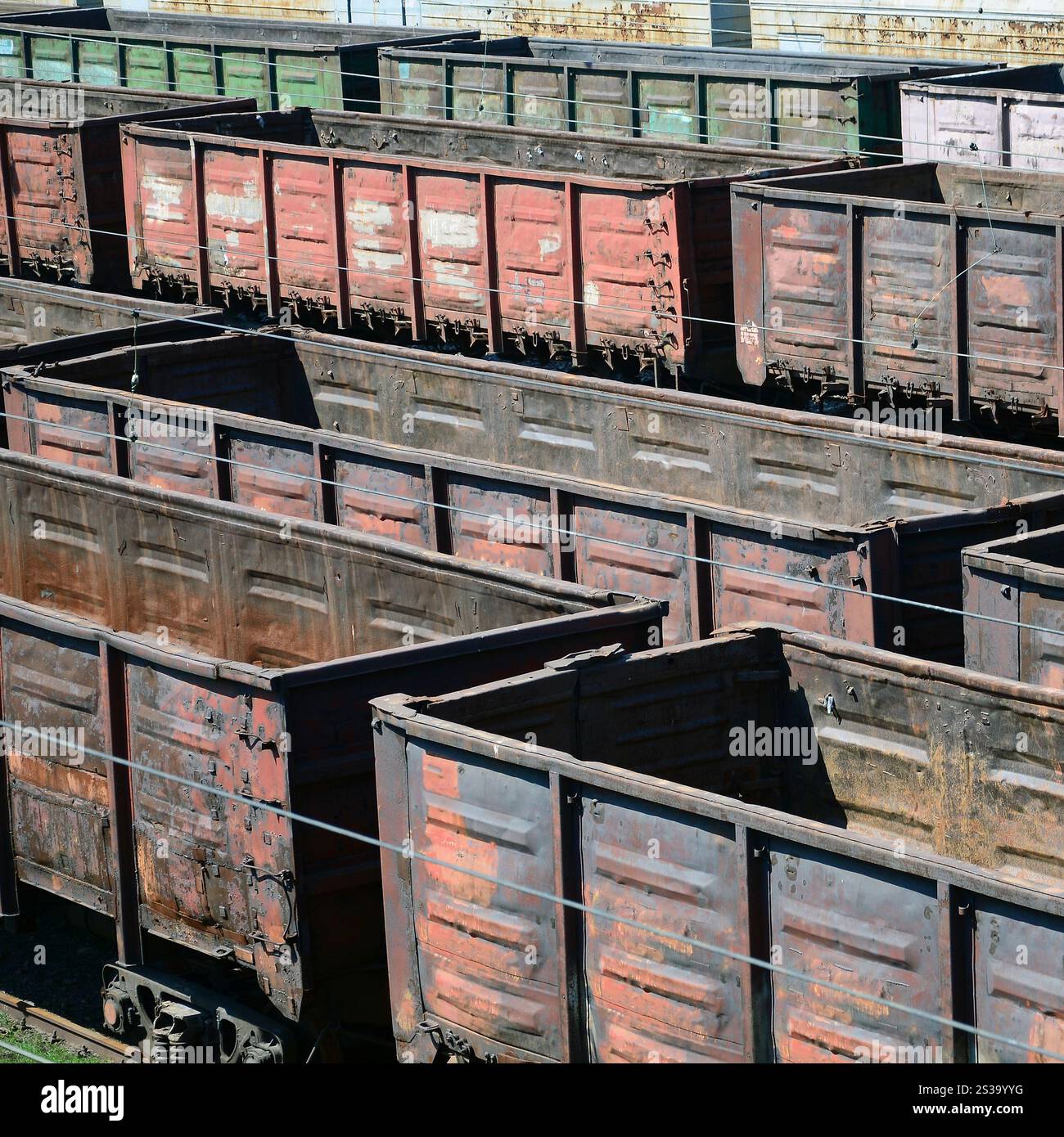 Vieux wagons de train rouillés vides sur les rails le jour d'été. Wagons sales à la lumière du soleil sous l'air libre. Vieux wagons de train rouillés vides sur les rails le jour d'été Banque D'Images