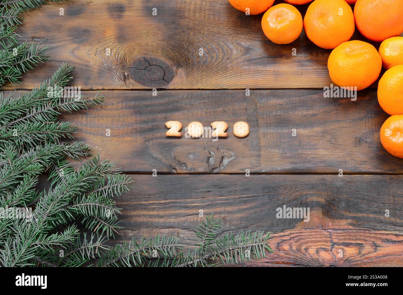 Carte de vacances de Noël avec mandarines, craquelin 2020 chiffres et branches de sapin avec espace de copie. Vue de dessus, pose à plat. Mandarines, craquelins 2020 chiffres et Banque D'Images