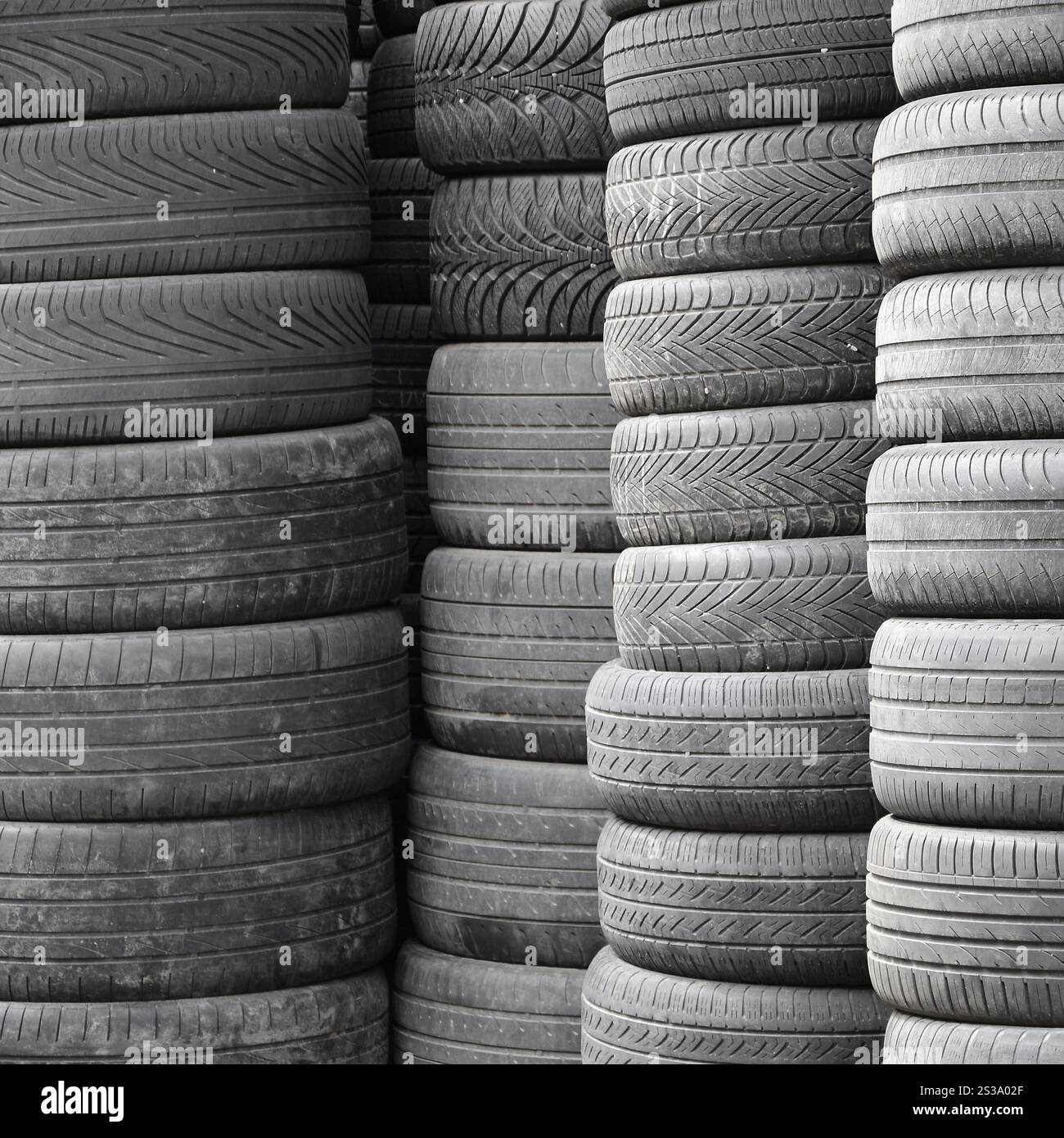 Vieux pneus usagés empilés avec des piles élevées dans le garage secondaire de magasin de pièces de voiture de près. Vieux pneus usagés empilés avec des piles élevées dans des pièces de voiture secondaires Banque D'Images