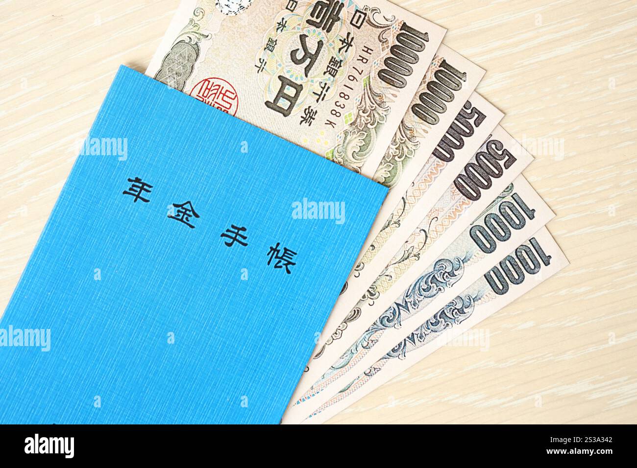 Livre d'assurance pension japonais sur table avec des billets d'argent en yen. Le livre bleu pour les retraités japonais se rapproche. Livre d'assurance pension japonais sur table avec Banque D'Images