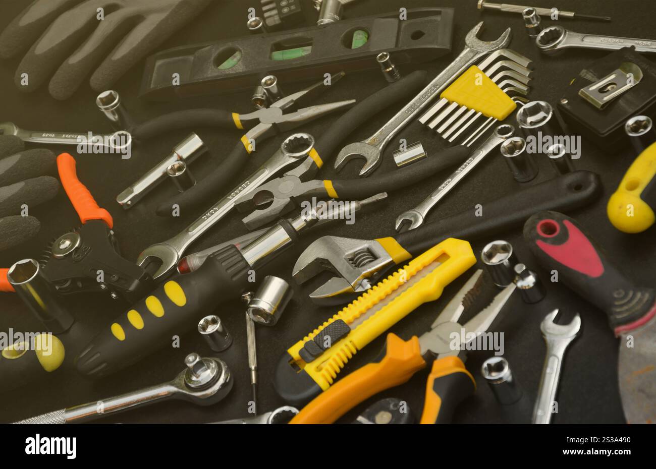 Kit d'outils bricoleur sur table en bois noir. De nombreuses clés et tournevis, pilers et autres outils pour tout type de travaux de réparation ou de construction. Banque D'Images