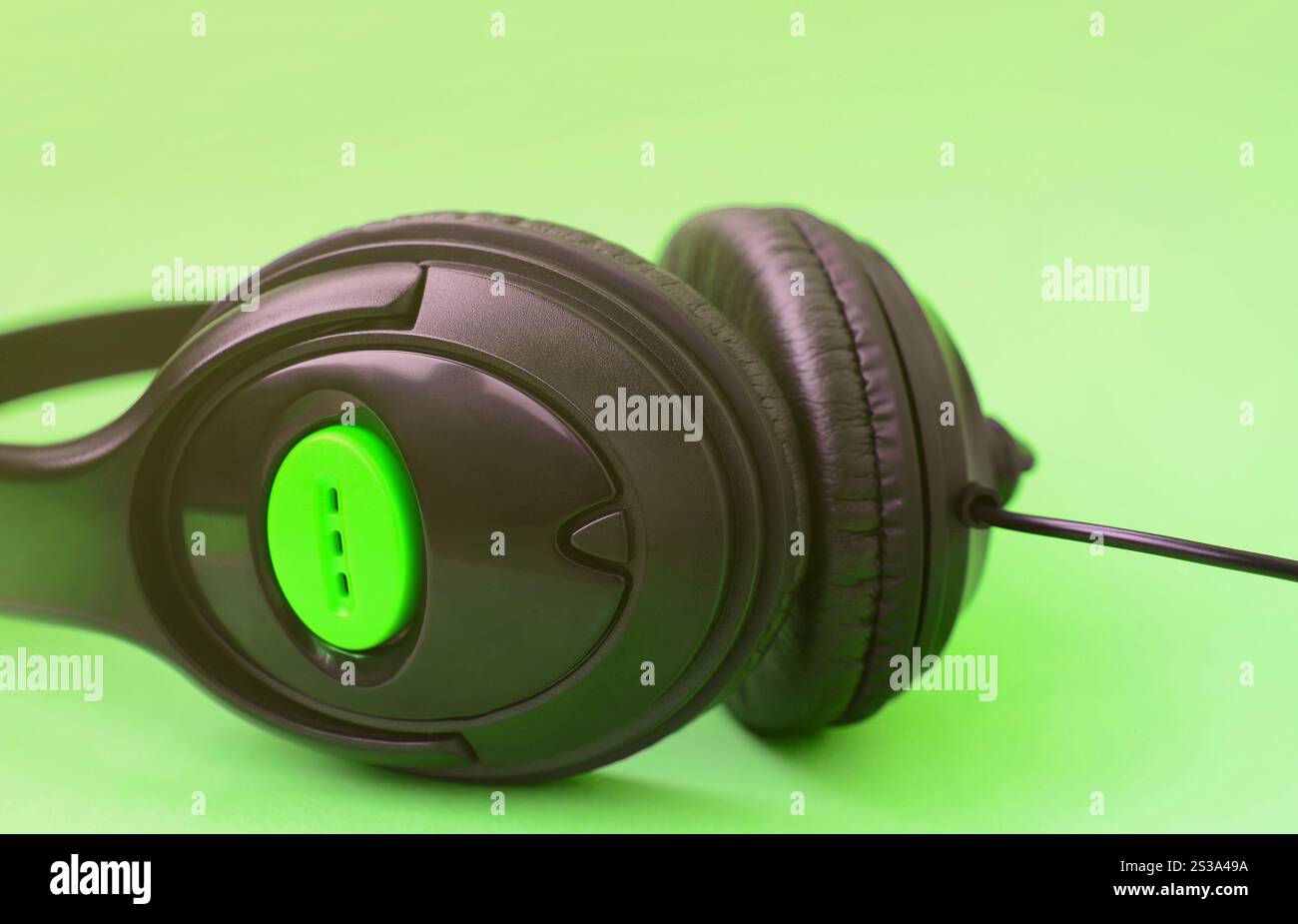 Casque noir repose sur un fond vert pastel coloré. Concept d'écoute de musique. Concept d'écoute de musique. Casque noir repose sur le vert Banque D'Images