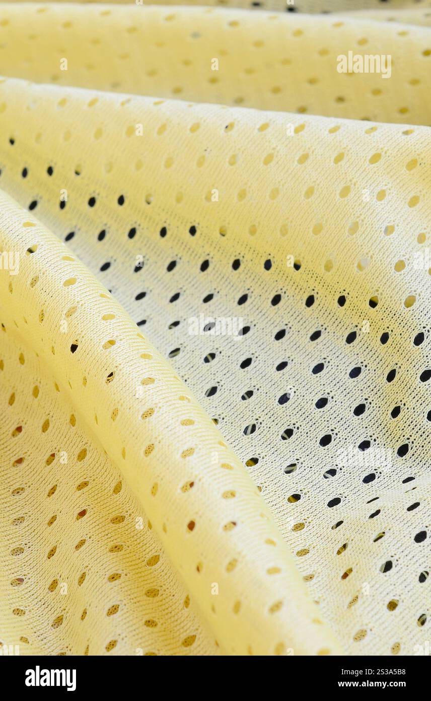 Fond de modèle textile de tissu de tissu de sport de maille jaune. Couleur jaune maillot de football vêtements tissu texture vêtements de sport. Poreux respirant Banque D'Images