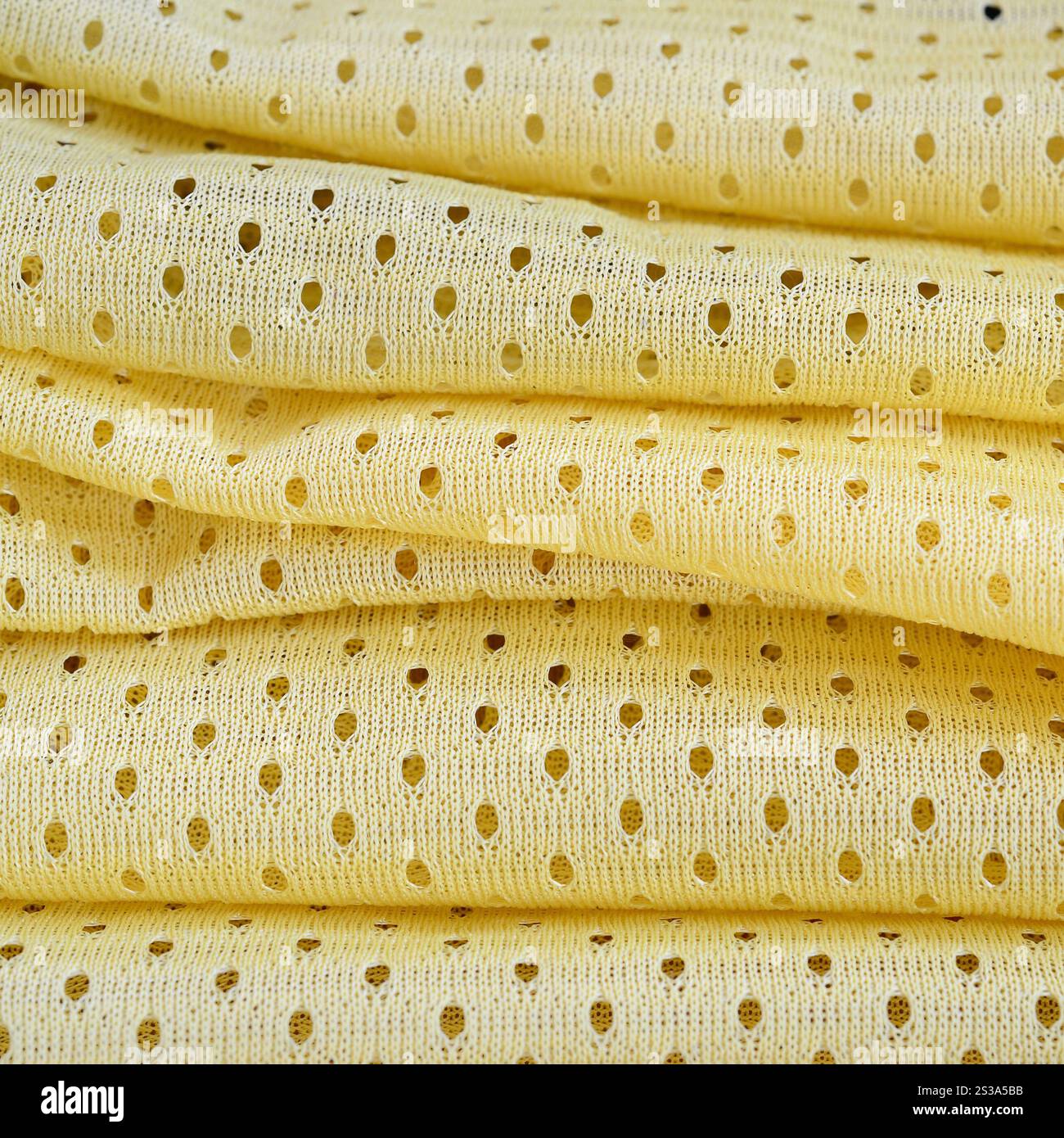 Fond de modèle textile de tissu de tissu de sport de maille jaune. Couleur jaune maillot de football vêtements tissu texture vêtements de sport. Poreux respirant Banque D'Images