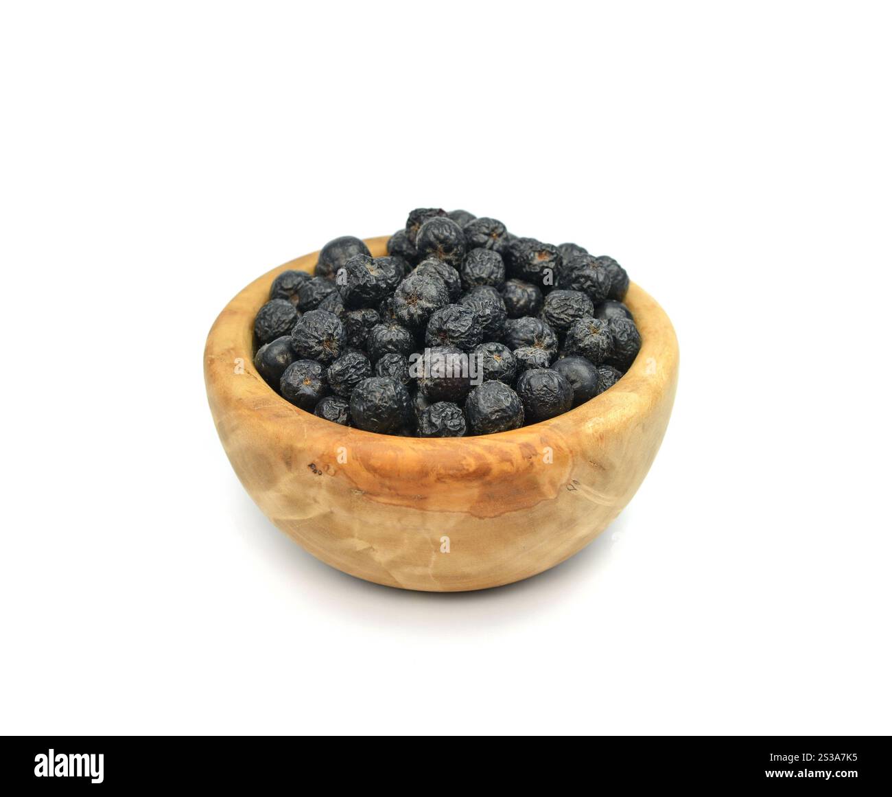 Baies d'Aronia dans un bol en bois isolé sur fond blanc. Baies noires de chokeberry ou d'aronia, isolées sur fond blanc. Banque D'Images
