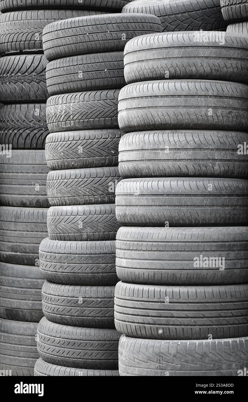 Vieux pneus usagés empilés avec des piles élevées dans le garage secondaire de magasin de pièces de voiture de près. Vieux pneus usagés empilés avec des piles élevées dans des pièces de voiture secondaires Banque D'Images