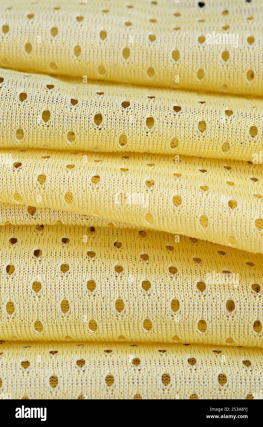Fond de modèle textile de tissu de tissu de sport de maille jaune. Couleur jaune maillot de football vêtements tissu texture vêtements de sport. Poreux respirant Banque D'Images