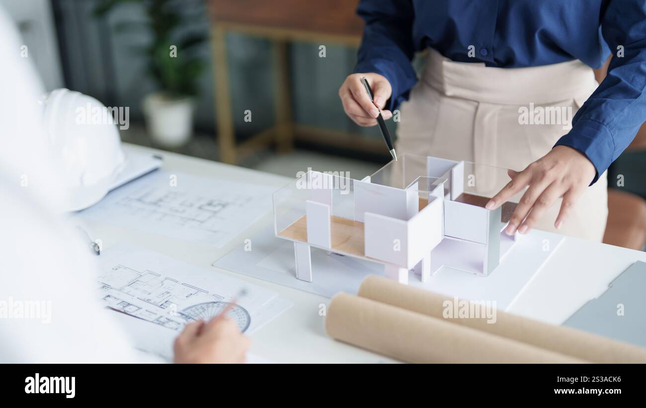 Modèle de maison sur Buleprint construction dessin et équipement de dessin stationnaire architecte analysant maison modèle moderne dans la main architecte Design Banque D'Images