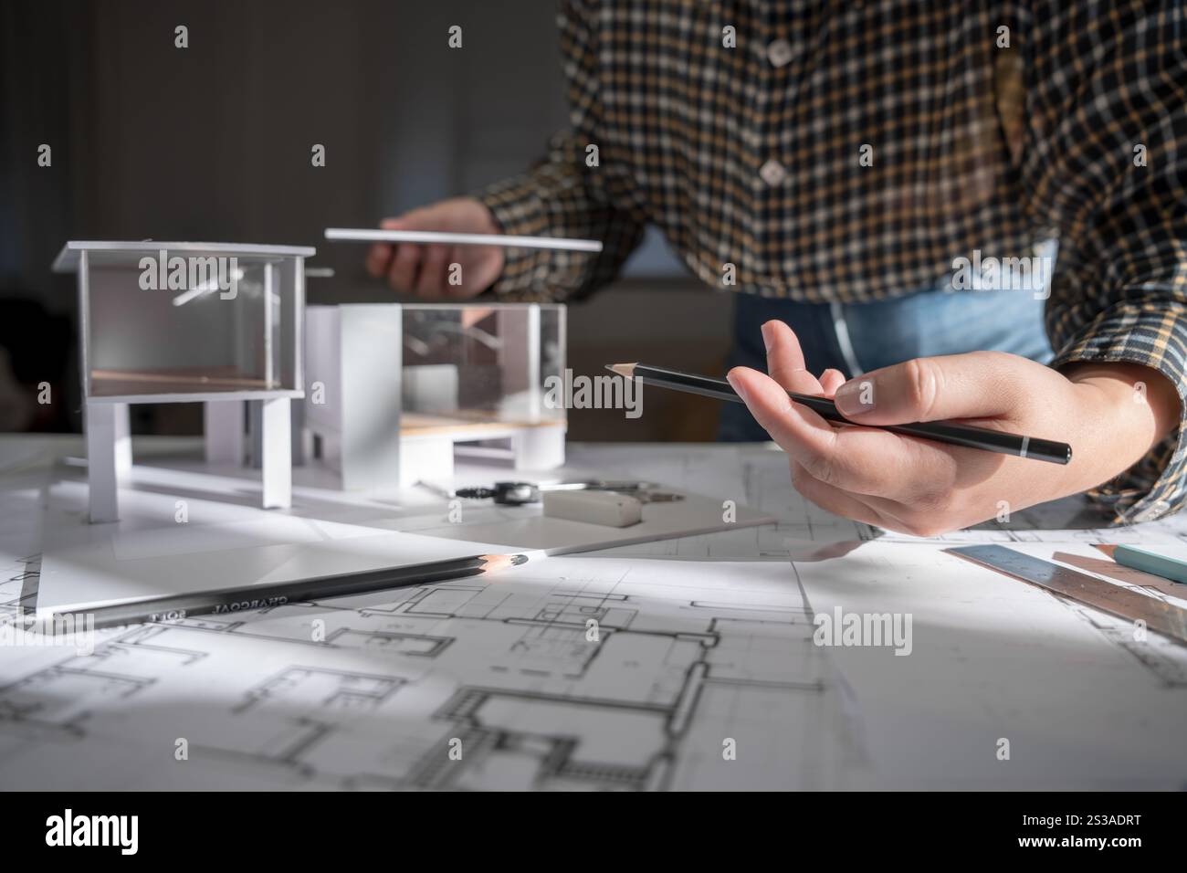 Modèle de maison sur Buleprint construction dessin et équipement de dessin stationnaire architecte analysant maison modèle moderne dans la main architecte Design Banque D'Images