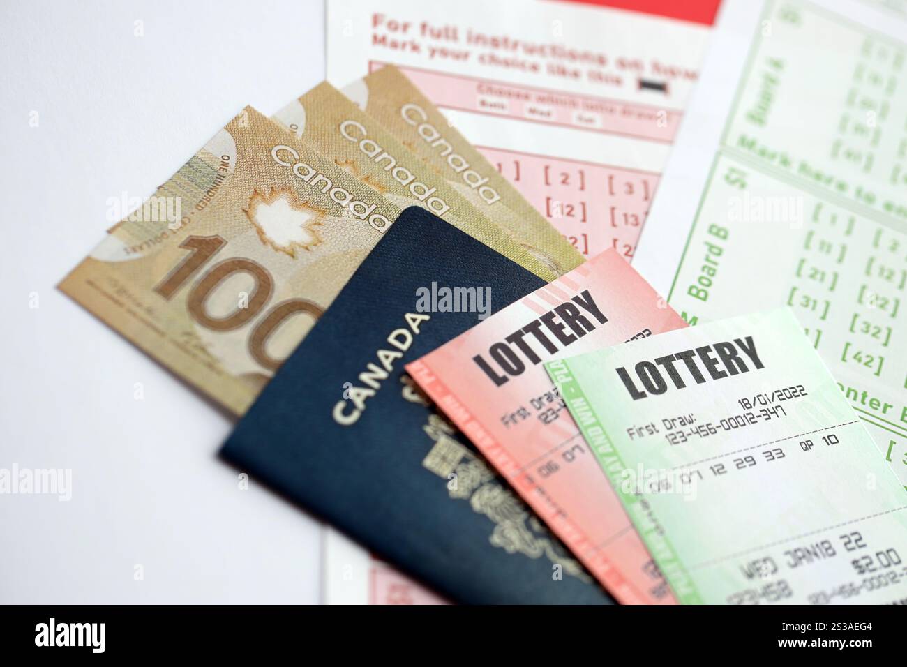 Billets de loterie se trouve avec des dollars canadiens sur des feuilles de jeu avec des numéros pour marquer pour jouer à la loterie. Concept de jeu de loterie ou jeu Banque D'Images