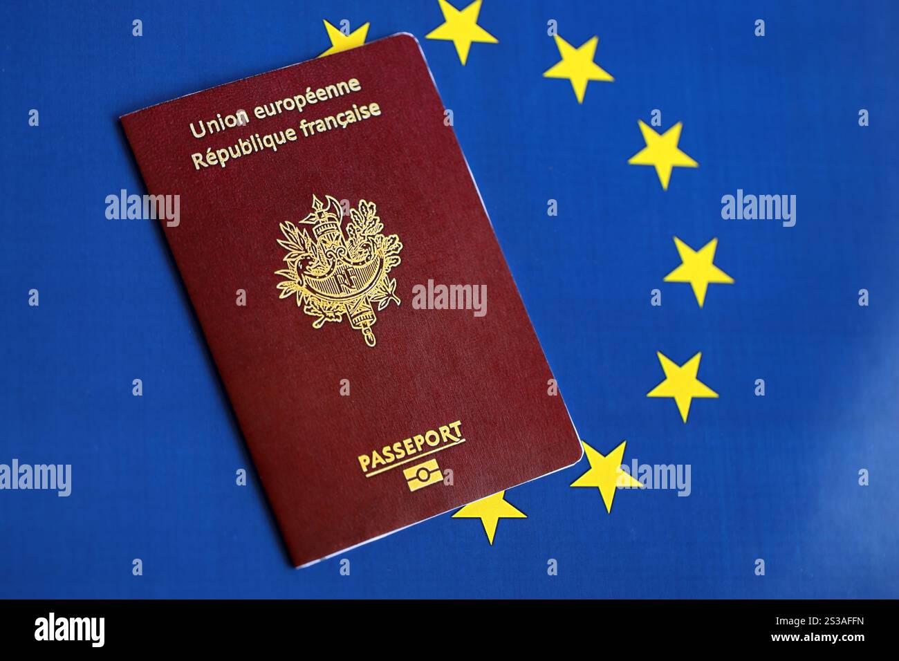 Passeport français de l'Union européenne sur fond de drapeau bleu gros plan. Tourisme et concept de citoyenneté. Passeport français de l'Union européenne sur drapeau bleu Banque D'Images