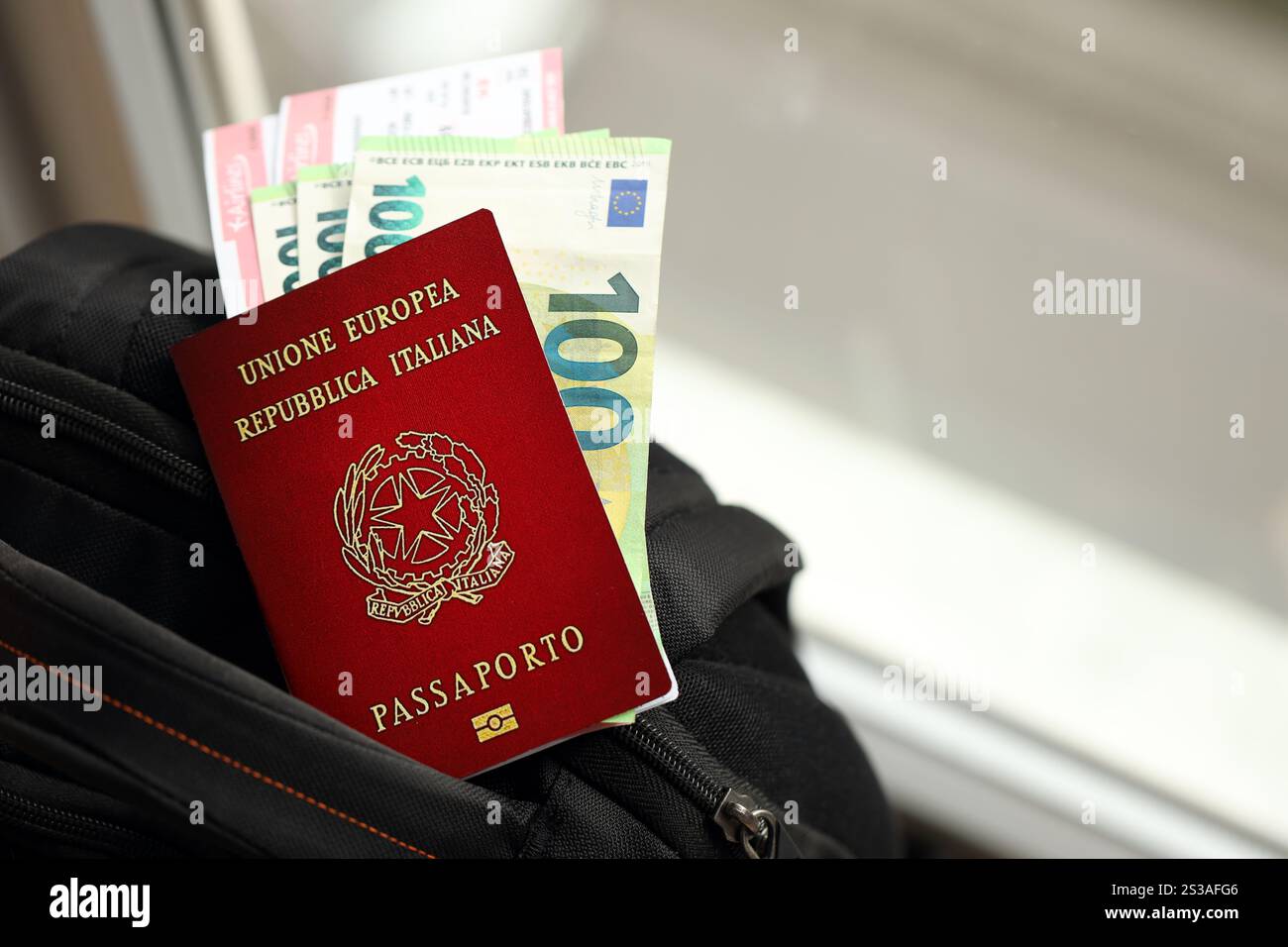Passeport italien et billets d'argent en euros avec billets d'avion sur sac à dos gros plan. Passeport italien et billets d'argent en euros avec billets d'avion sur Banque D'Images
