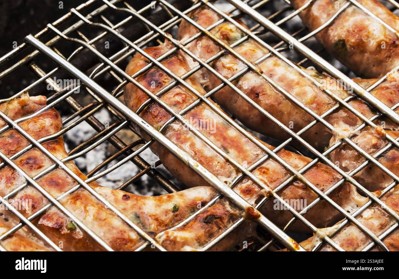 saucisses grillées sur le gril flamboyant en gros plan. saucisse grillée sur le gril flamboyant Banque D'Images saucisses grillées sur le gril flamboyant en gros plan. saucisse grillée sur le gril flamboyant Banque D'Images