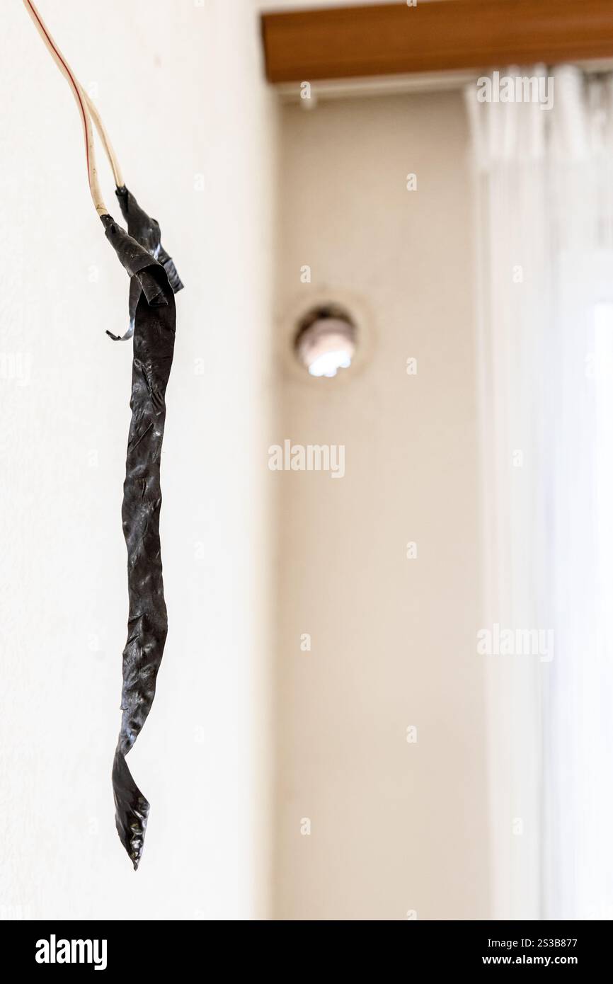 Fils électriques enveloppés de ruban isolant au premier plan pendant l'installation de la climatisation Banque D'Images