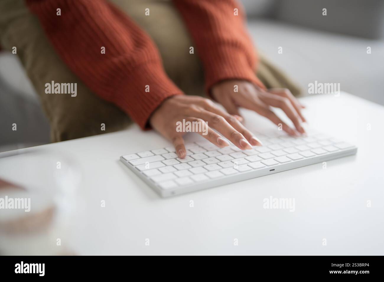 Belle femme asiatique travaillant en utilisant les mains d'ordinateur de clavier blanc bluetooth sans fil tapant sur le clavier. Concept d'entreprise technologique. Banque D'Images