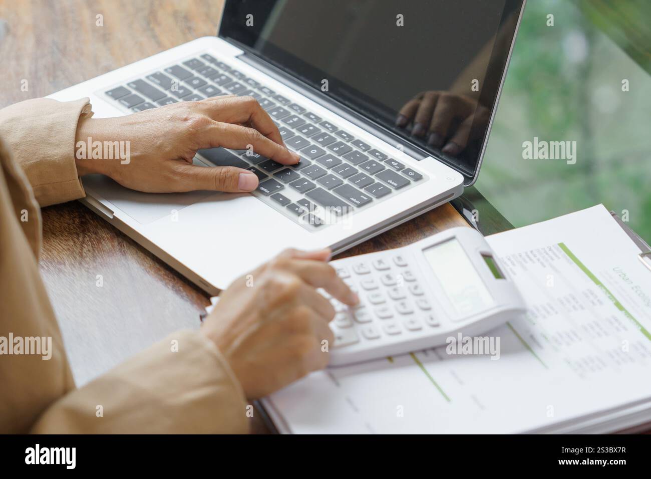 Femme d'affaires calculant l'état financier sur la calculatrice de déclaration d'impôt en ligne et de paiement Banque D'Images