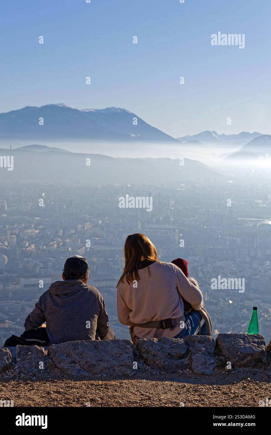 GRENOBLE, FRANCE, 1er janvier 2025 : couple avec un bébé admire la ville et les montagnes environnantes depuis la forteresse nommée la Bastille sur une colline au-dessus de G. Banque D'Images