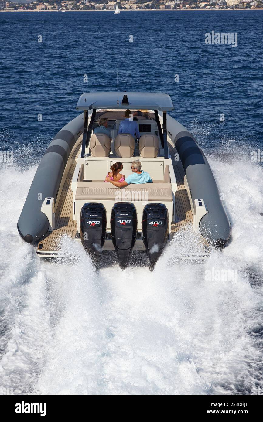 Puissants moteurs hors-bord Triple 400 CH propulsant un bateau à moteur moderne élégant à grande vitesse sur la mer. Banque D'Images