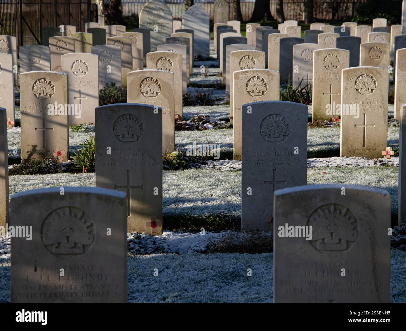 Rangées de tombes militaires avec des pierres tombales dans un cimetière, avec la lumière du soleil projetant des ombres et Frost Durrington cimetière britannique des tombes de guerre du Commonwealth Banque D'Images