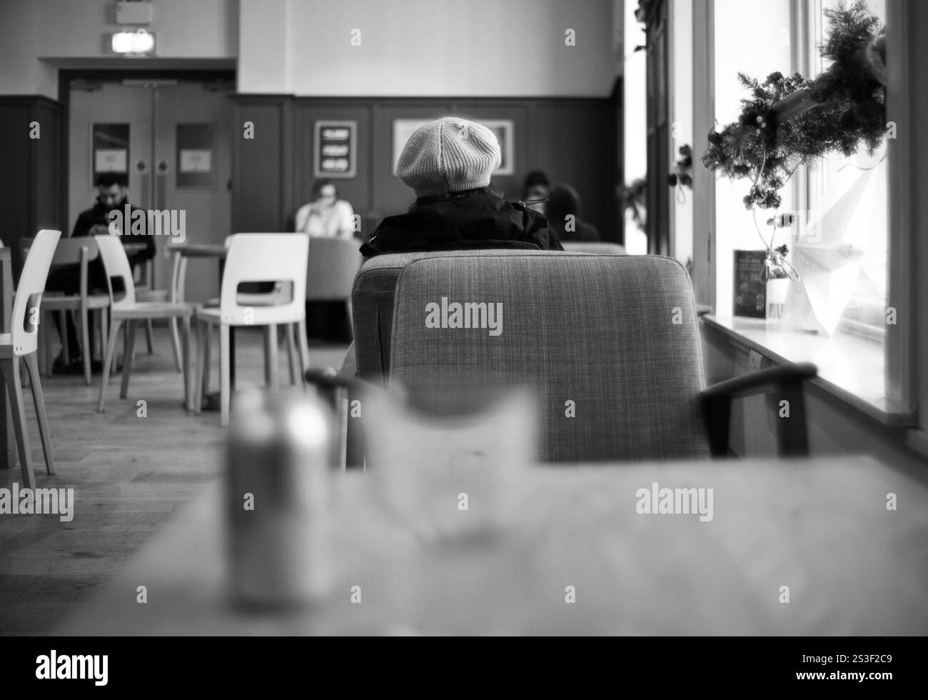 Intérieur d'un café avec des gens hors de focus en noir et blanc Banque D'Images