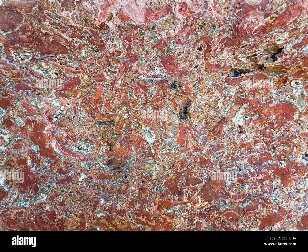 Fond de surface de roche rouge rugueux. Gros plan. Banque D'Images