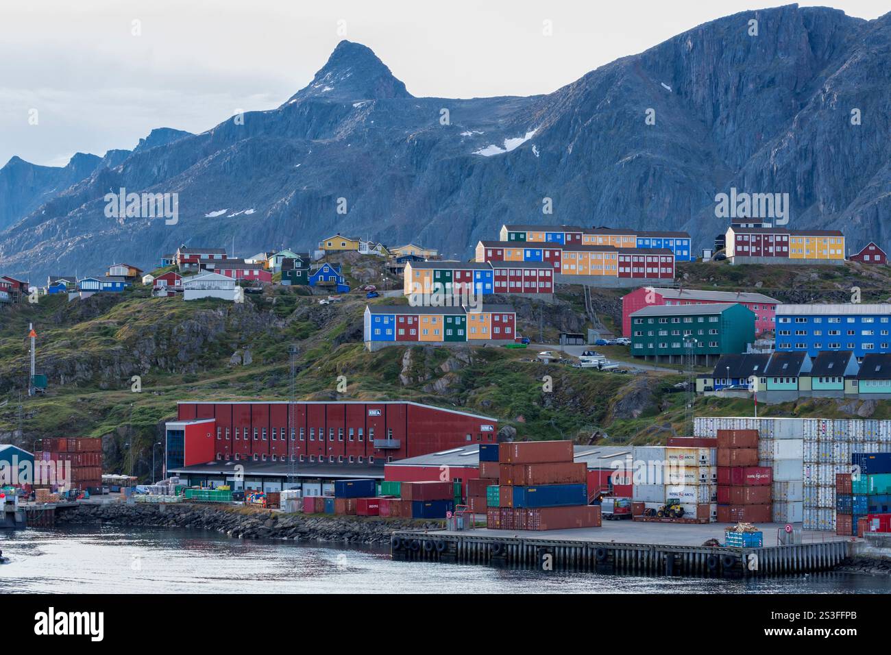 Le port de Sisimiut avec des conteneurs empilés, derrière lui des bâtiments colorés et le massif Nasaasaq. Sisimiut, centre-ouest du Groenland, Danemark Banque D'Images