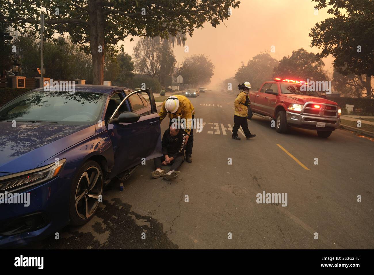 Pacific Palisades, Californie, États-Unis. 9 janvier 2025. un résident retenu par un pompier alors qu'il était désemparé et ivre. Il a brisé les lignes de police avec sa voiture et a regardé sa maison brûler alors que les pompiers l'éteignaient sans succès. Les pompiers ont continué à combattre quotidiennement l'incendie intense de Pacific Palisades, Californie avec des vents élevés de Santa Ana atteignant jusqu'à 85 miles à l'heure. Cinq feux de forêt majeurs faisant rage dans le comté de Los Angeles, le comté le plus peuplé des États-Unis, ont tué au moins 5 personnes et forcé des dizaines de milliers de résidents à être évacués. (Crédit IM Banque D'Images