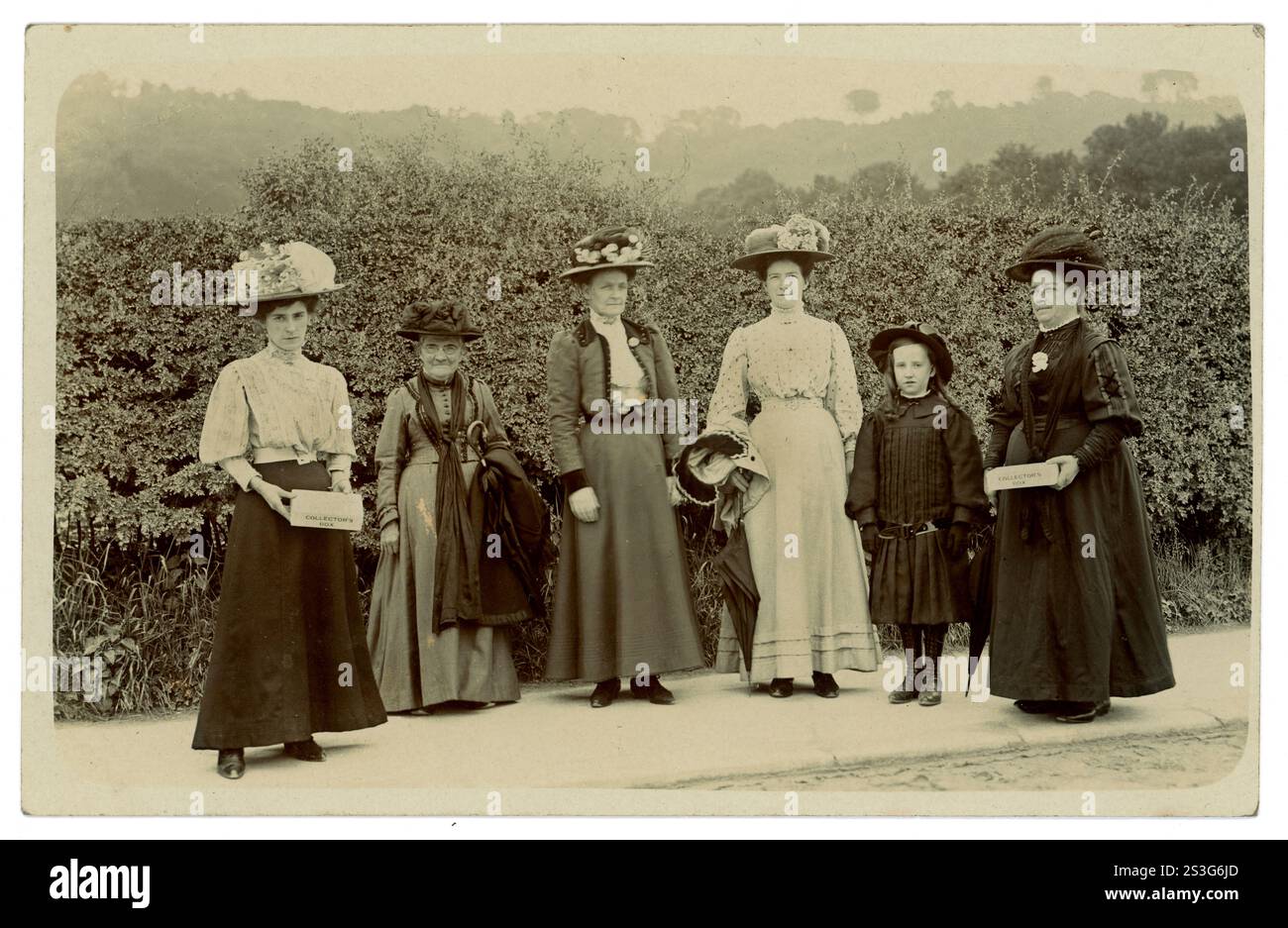 Carte postale originale de l'ère édouardienne d'un groupe de collecteurs bénévoles féminins de charité, bonnes personnes de la paroisse de différents âges, tenant la boîte des collecteurs. Sont-elles des membres féministes de la Women’s Freedom League (WFL) ou de l’Union sociale et politique des femmes (WSPU) qui font campagne pour le suffrage des femmes ou collectent des fonds pour une cause digne comme les pauvres de la paroisse ou pour les fonds de l’église ? Belle sélection de chapeaux. Circa 1906, Royaume-Uni Banque D'Images