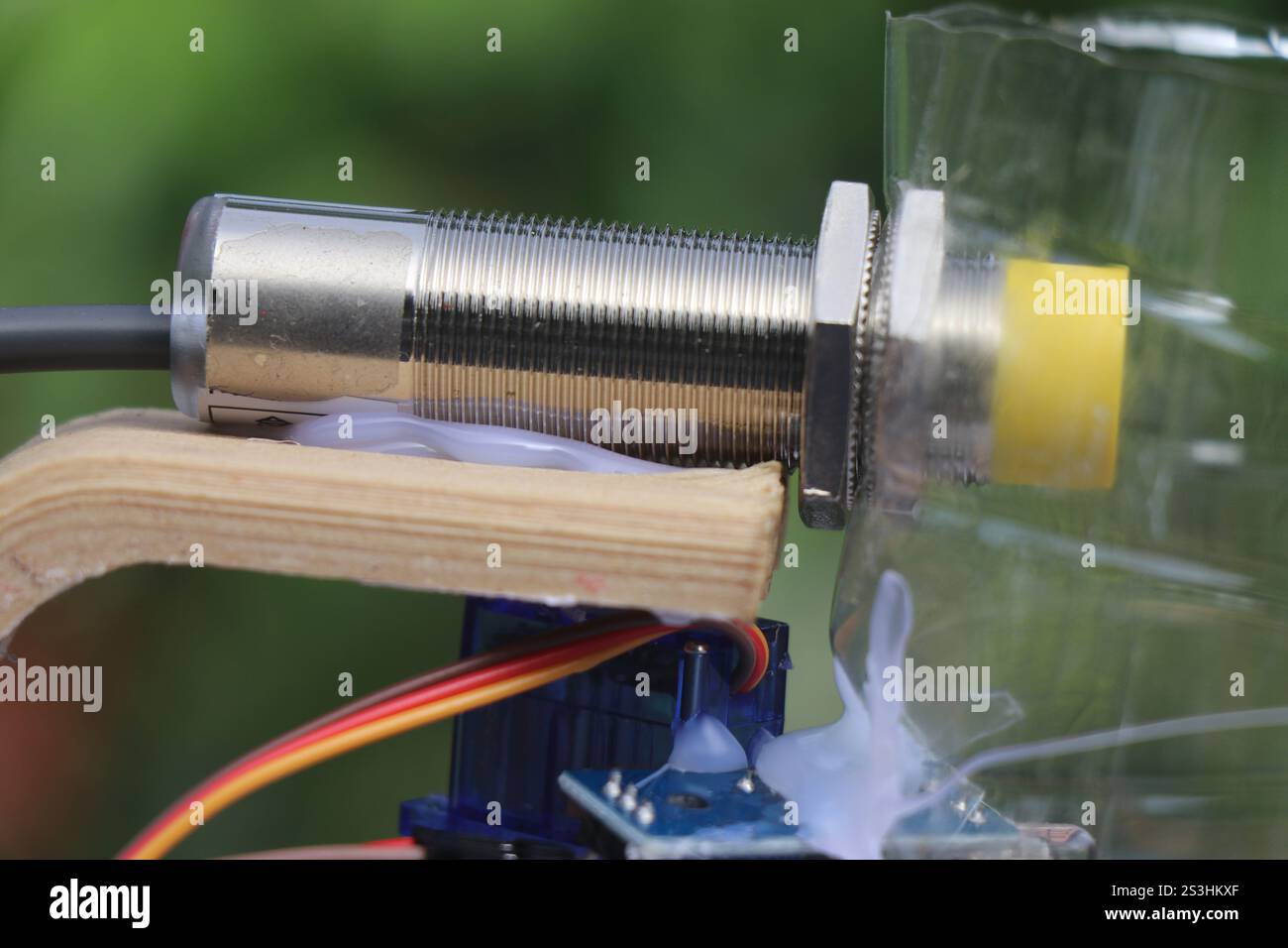 Vue rapprochée du capteur de proximité de type npn avec micro servo sur fond naturel Banque D'Images
