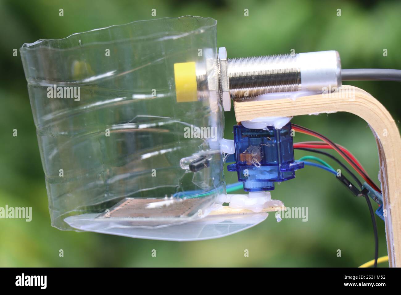 Vue d'un projet électronique réalisé à l'aide de micro servo et capteur de proximité capacitif de type npn isolé sur fond naturel Banque D'Images