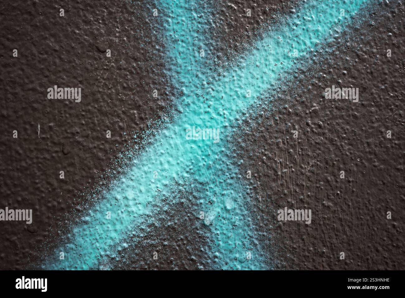 Peinture en aérosol en forme de x bleu sur un mur rugueux Banque D'Images
