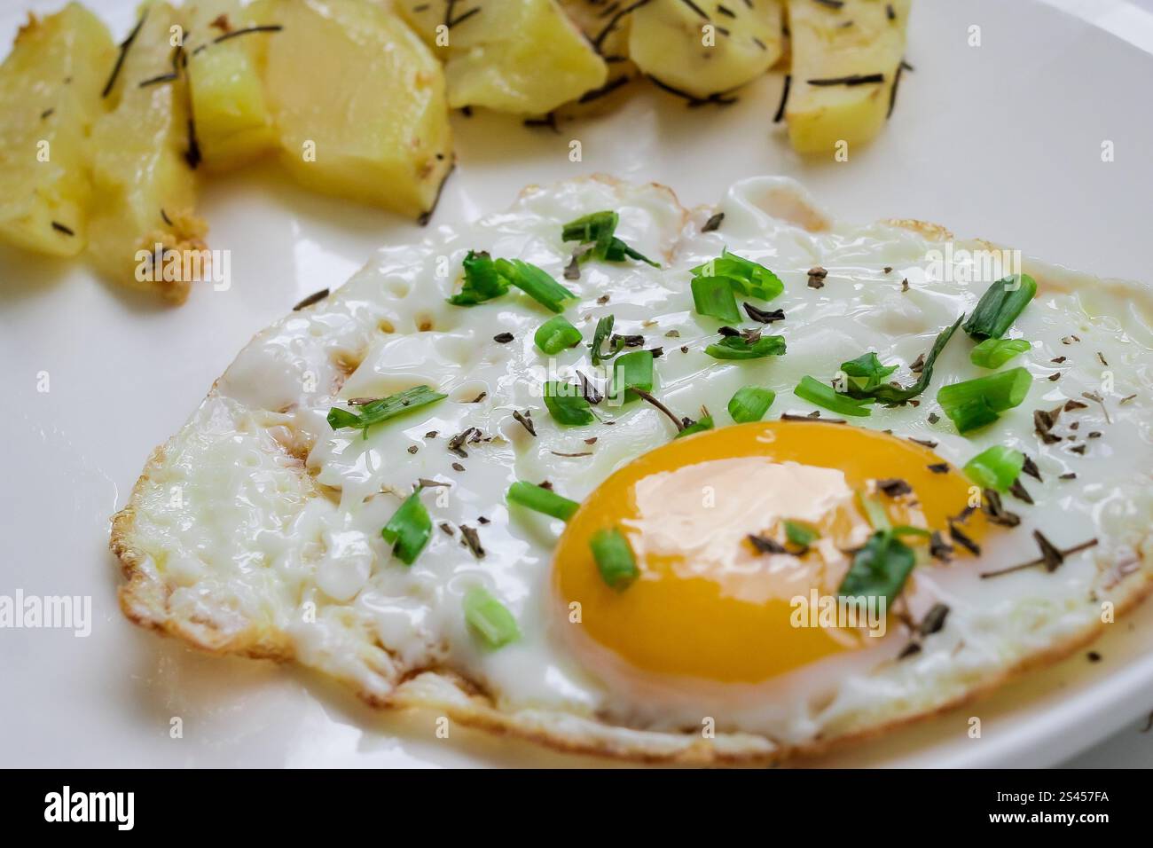 oeuf frit avec pain grillé décoré de petits pois verts sur assiette blanche. avec pomme de terre pour le petit déjeuner Banque D'Images