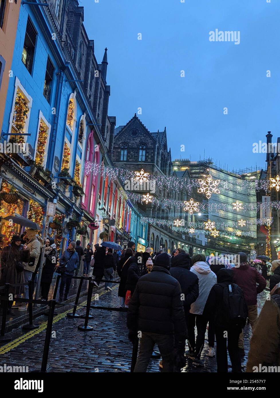 Charme festif au cœur de la ville - lumières scintillantes, façades colorées, et une foule animée embrassant l'esprit des fêtes. Banque D'Images