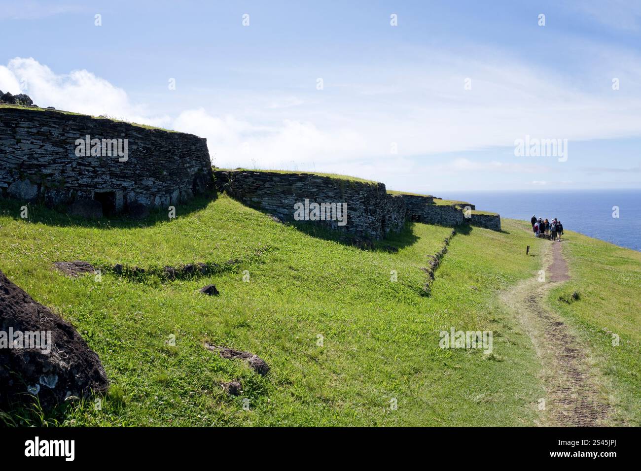 Le groupe visite Orongo, des bâtiments recouverts de gazon, sans fenêtre, qui étaient un ancien village cérémoniel sur le volcan Rano Kau, île de Pâques. Banque D'Images