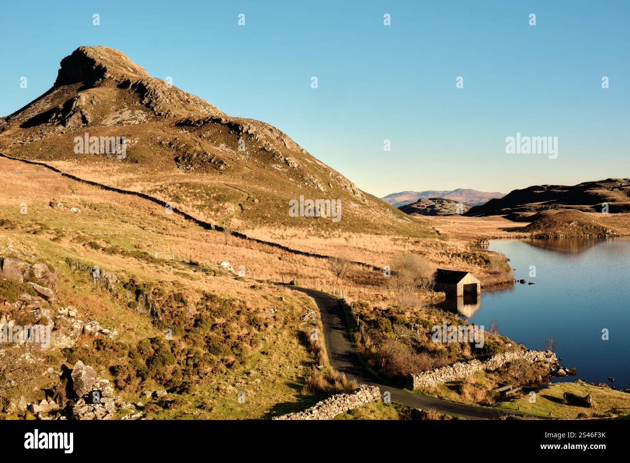 Une maison de bateau se trouve au bord des lacs de Cregennan, ou Llynnau Cregennan, près d'Arthog, Dolgellau, au nord du pays de Galles avec la crête de Pared y Cefn hîr au-dessus. Banque D'Images