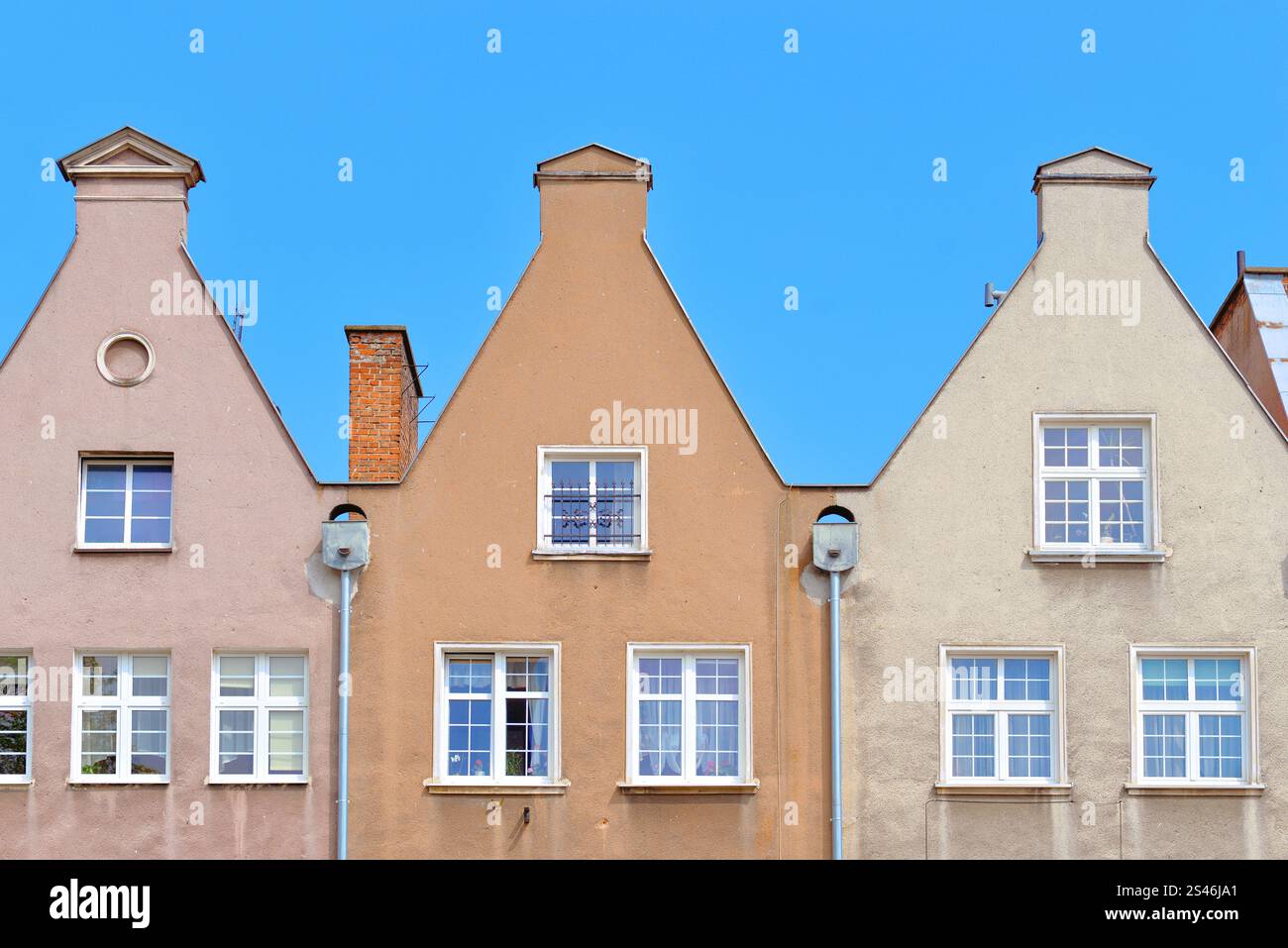 Toits de trois vieilles maisons historiques à Gdansk contre le ciel. Banque D'Images